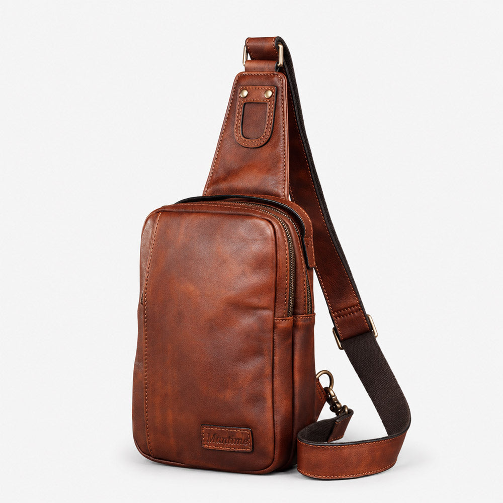 Brown full-grain leather waist bag in a compact bum bag design with front leather logo patch and adjustable strap